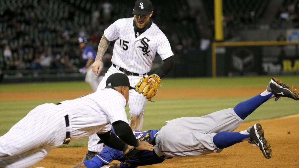 Chicago first baseman Jose Abreu, left, tags out Texas’ Ian Desmond at first for the second out of a triple play as White Sox second baseman Brett Lawrie (15) watches.