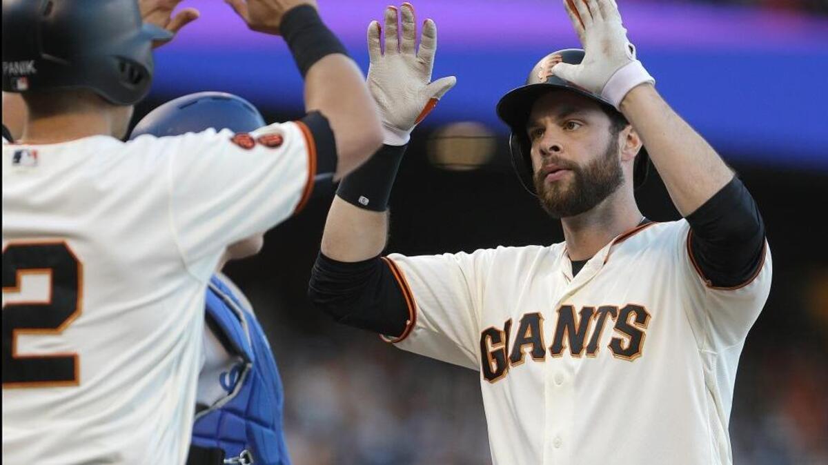 Giants first baseman Brandon Belt, right, celebrates with Joe Panik (12) after hitting a two-run home run off Los Angeles Dodgers pitcher Julio Urias in the sixth inning of a baseball game, Sunday, June 12, 2016, in San Francisco. The Giants won 2-1 and have beaten the Dodgers six times in 10 games this season.