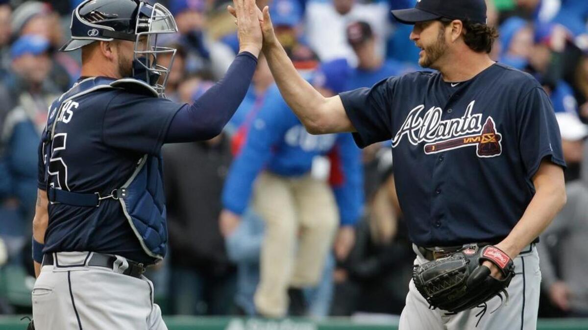 Atlanta Braves relief pitcher Jason Grilli, right, celebrates with catcher Tyler Flowers after they defeated the Chicago Cubs 4-3 in a baseball game Sunday, May 1, 2016, in Chicago.
