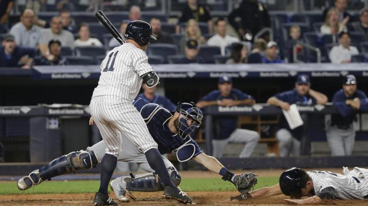 Jacoby Ellsbury of the Yankees slides in under the tag of Tampa Bay catcher Curt Casali as Brett Gardner of the Yankees bails out of the batter’s box on Friday, April 22, 2016, in New York.