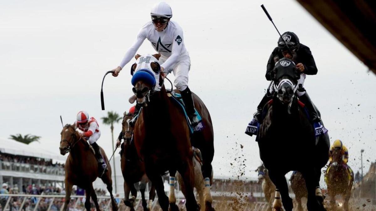 Jockey Flavien Prat, center, celebrates aboard Battle of Midway after beating second-place Sharp Azteca, ridden by jockey Paco Lopez, in the Las Vegas Dirt Mile horse race during the first day of the Breeders' Cup on Friday in Del Mar.