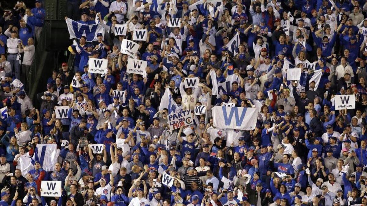The National League Championship Series returns Tuesday to Wrigley Field, where optimistic Cubs fans hope to wave “W” flags, as they do following a victory. They are shown here following the Cubs’ Game 4 win over the St. Louis Cardinals in the National League Division Series.
