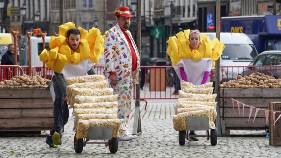 Wearing French fry costumes and pushing bags of unfried potatoes, IndyCar driver Alexander Rossi, left, and Yale debater Evan Lynyak compete in a “Friet Race” during “The Amazing Race.”