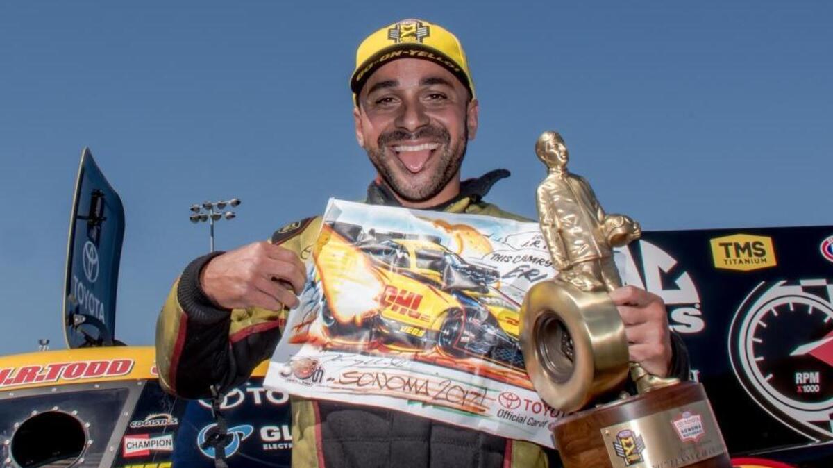 J.R. Todd shows off his Funny Car trophy after a victory over Tim Wilkerson in the NHRA Sonoma Nationals on Sunday at Sonoma Raceway.