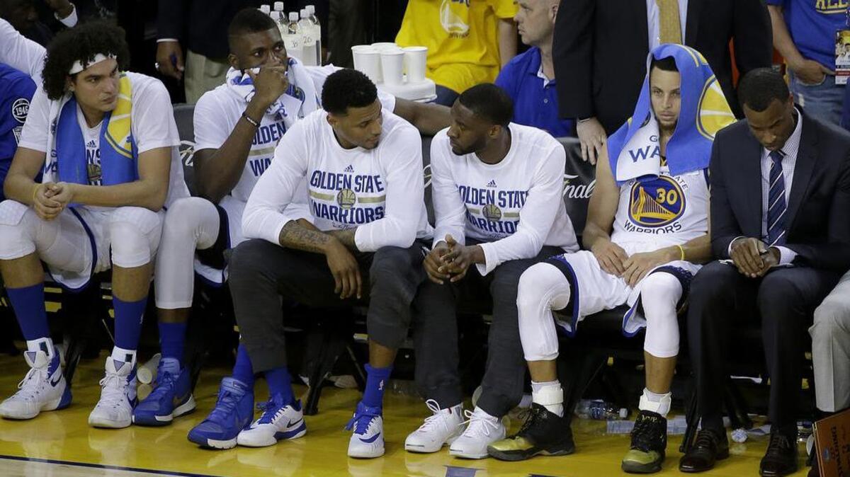 Golden State Warriors guard Stephen Curry (30) and teammates sit on the bench during the second half of Game 7 of the NBA Finals between the Warriors and the Cleveland Cavaliers in Oakland, Calif., Sunday, June 19, 2016. The Cavaliers won 93-89 to win the series.