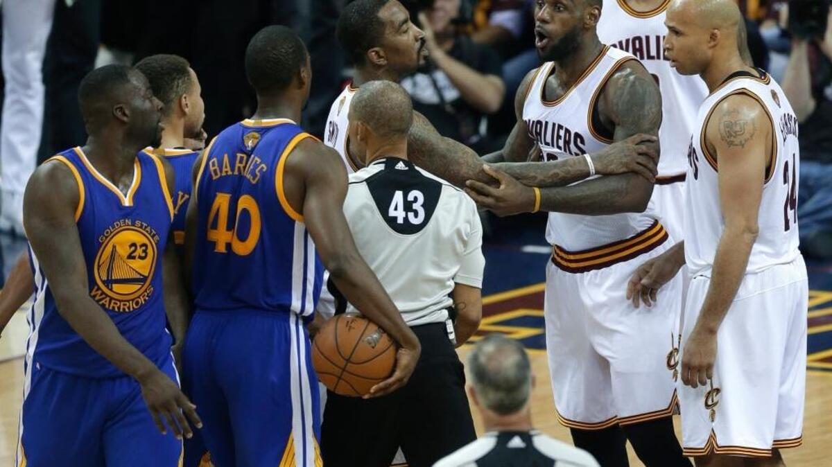 A teammate holds Cleveland star LeBron James back after his Game 4 run-in with Warriors forward Draymond Green (23). Green was suspended for Monday’s Game 5 for delivering a shot to James’ groin.