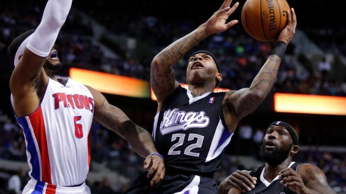 Sacramento Kings guard Isaiah Thomas (22) goes to the basket against Detroit Pistons forward Josh Smith (6) as Kings Reggie Evans (30), right, looks on during the first half of an NBA basketball game, Tuesday, March 11, 2014, in Auburn Hills, Mich.