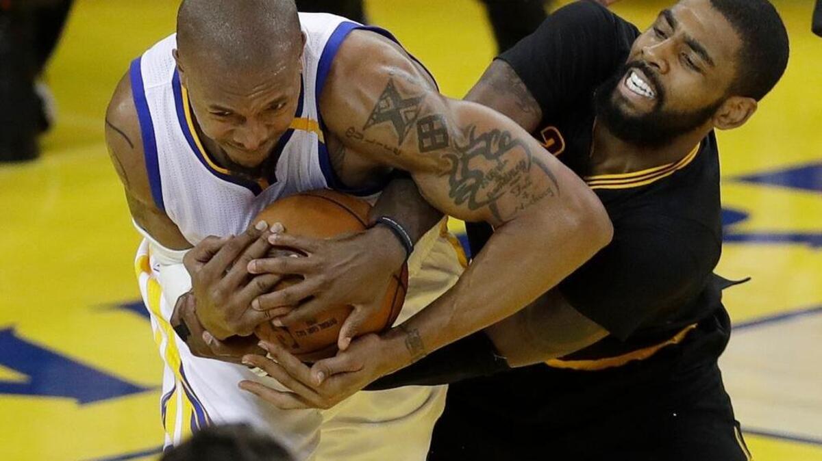 Golden State Warriors forward David West, left, wrestles for the ball with Cleveland Cavaliers guard Kyrie Irving during Game 5 of the NBA Finals on Monday in Oakland.
