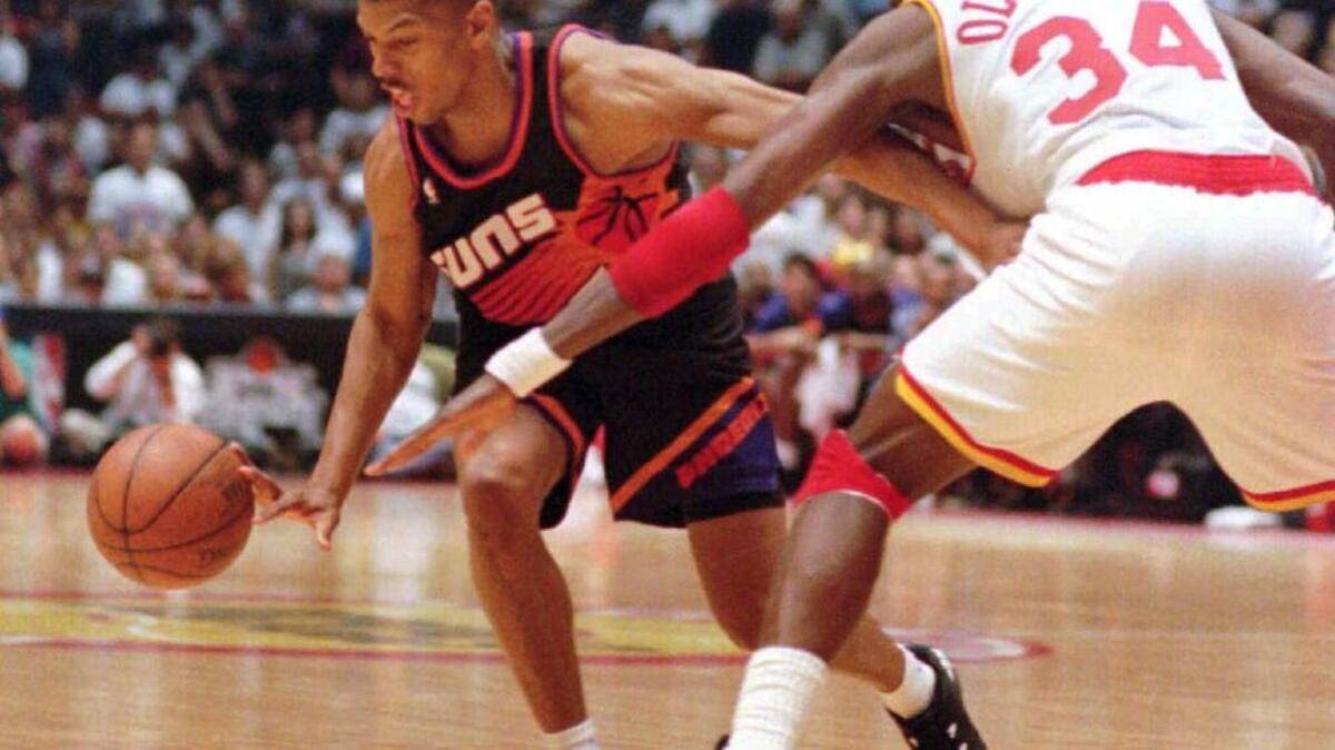 Houston center Hakeem Olajuwon, left, tries to steal the ball away from Phoenix guard Kevin Johnson during their Western Conference semifinal game on Sunday, May 14, 1995, in Houston. Johnson scored 43 points in the Suns' 114-110 victory over the Rockets, and take a 3-1 lead in the best-of-seven series.