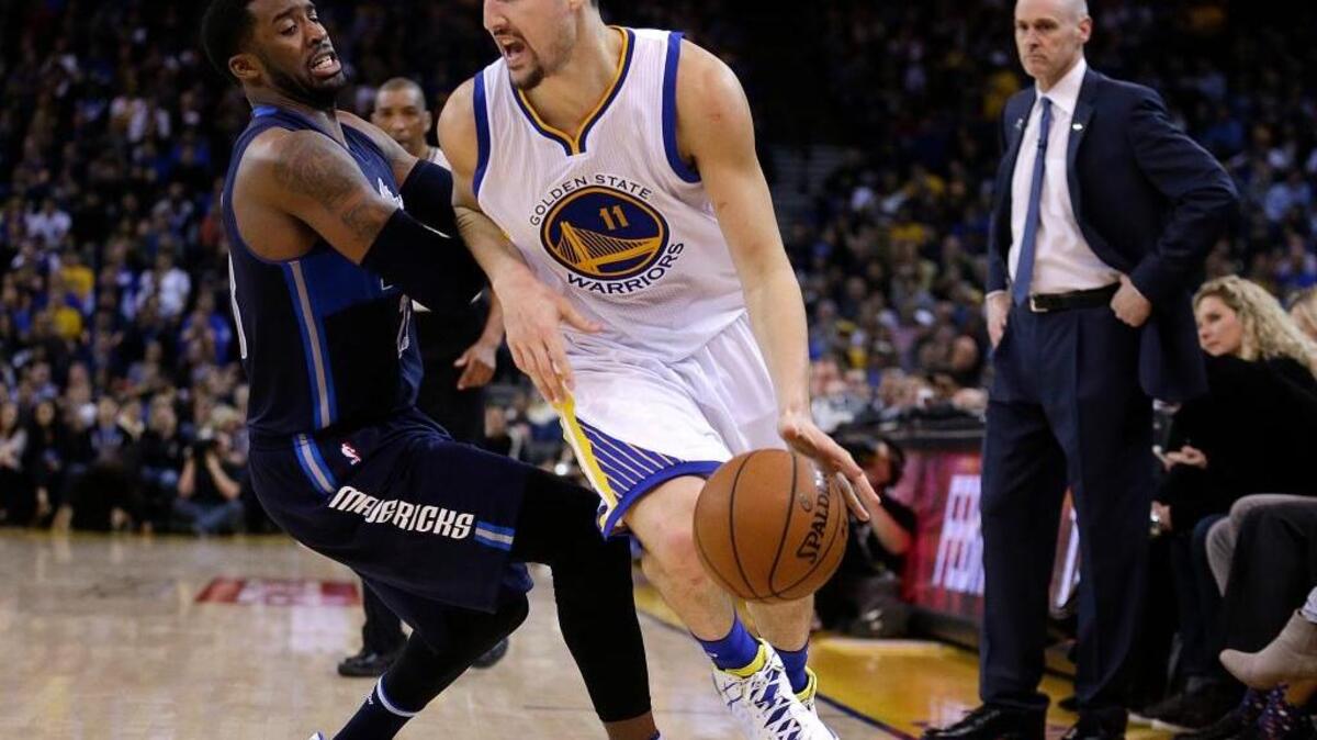 Klay Thompson drives the ball against the Mavericks’ Wesley Matthews during the second half of Wednesday night’s game in Oakland. Thompson scored 45 points in the Warriors’ 127-107.