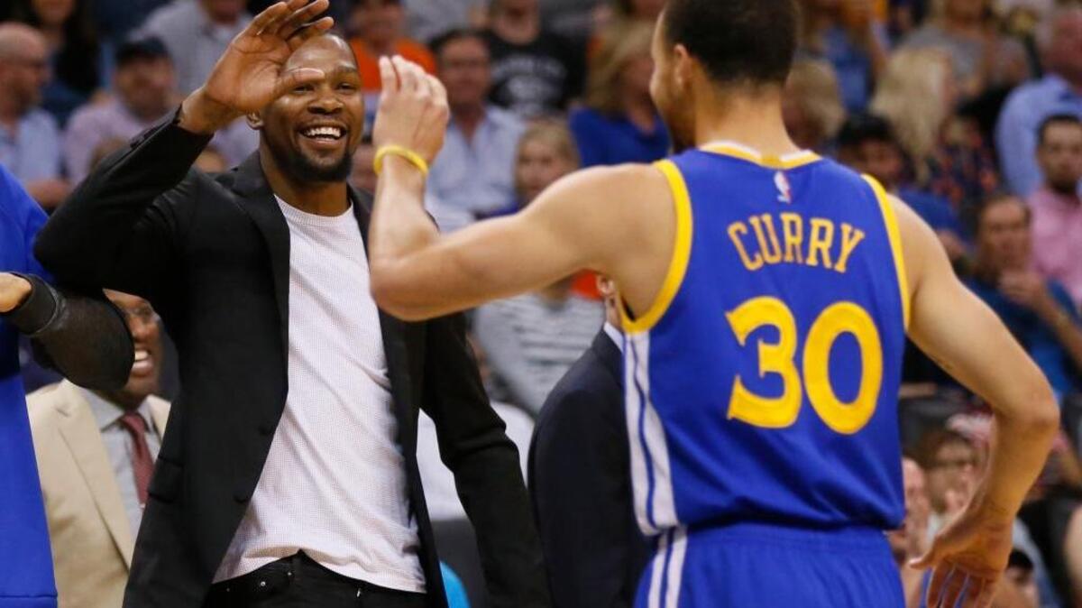 Injured Golden State Warriors forward Kevin Durant high-fives teammate Stephen Curry on March 20. Durant, who missed 20 regular-season games, has been forced to miss time in the postseason, too.