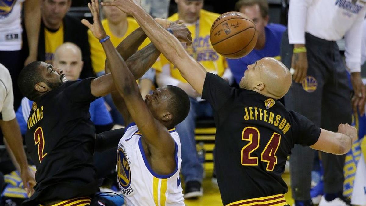 Golden State Warriors forward Harrison Barnes, center, loses the ball as he shoots between Cleveland Cavaliers forward Richard Jefferson (24) and guard Kyrie Irving during the first half of Game 5 of the NBA Finals in Oakland on Monday, June 13, 2016.