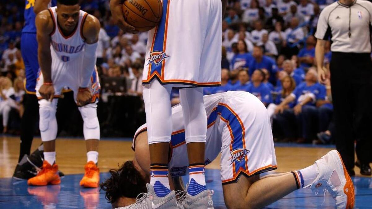 The Oklahoma City Thunder’s Steven Adams (12) kneels on the ground after being kicked by the Golden State Warriors’ Draymond Green (23) during the second quarter of an NBA playoff game, Sunday, May 22, 2016 in Oklahoma City. Green was not suspended for the play.