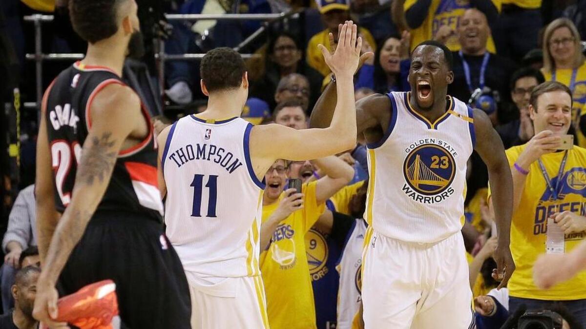 Golden State Warriors forward Draymond Green (23) and guard Klay Thompson celebrate during their 121-109 victory over the Portland Trail Blazers on Sunday in Oakland. The Warriors lead the first-round playoff series 1-0.