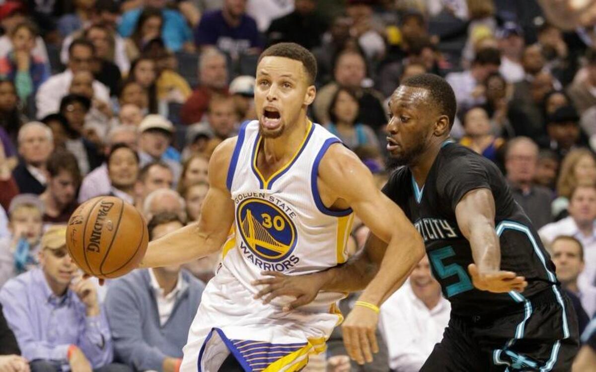 Golden State Warriors guard Stephen Curry, left, drives past Charlotte Hornets guard Kemba Walker in the second half of an NBA basketball game Wednesday, Dec. 2, 2015 in Charlotte, N.C. Curry scored 40 points in three quarters and the Warriors defeated the Hornets 116-99 to extend the best start in NBA history to 20-0.