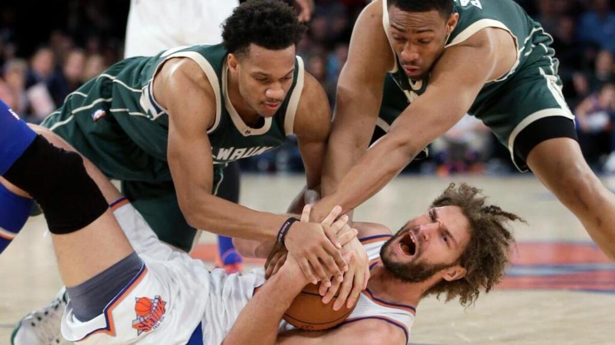 Milwaukee Bucks Rashad Vaughn, left, and Jabari Parker try to get the ball from the New York Knicks’ Robin Lopez, bottom, on Jan. 10, 2016 in New York. The Knicks defeated the Bucks 100-88.