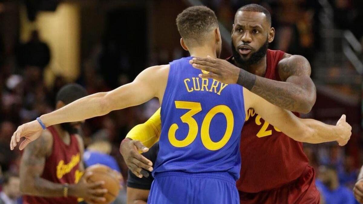 Cleveland Cavaliers forward LeBron James, right, hugs Golden State Warriors guard Stephen Curry before a game on Dec. 25, 2016, in Cleveland. The Christmas Day meeting was the first between the teams following their NBA Finals matchup, won by the Cavaliers.