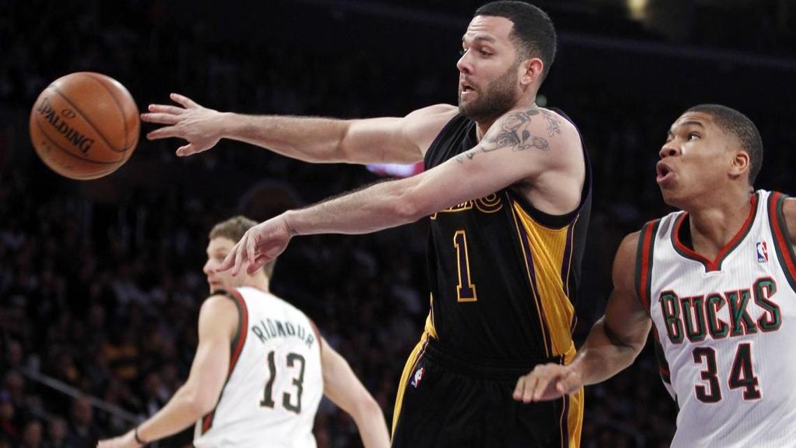 Los Angeles Lakers guard Jordan Farmar (1) passes the ball away from Milwaukee Bucks shooting guard Giannis Antetokounmpo (34 defending during the first half of an NBA basketball game Tuesday, Dec. 31, 2013, in Los Angeles.