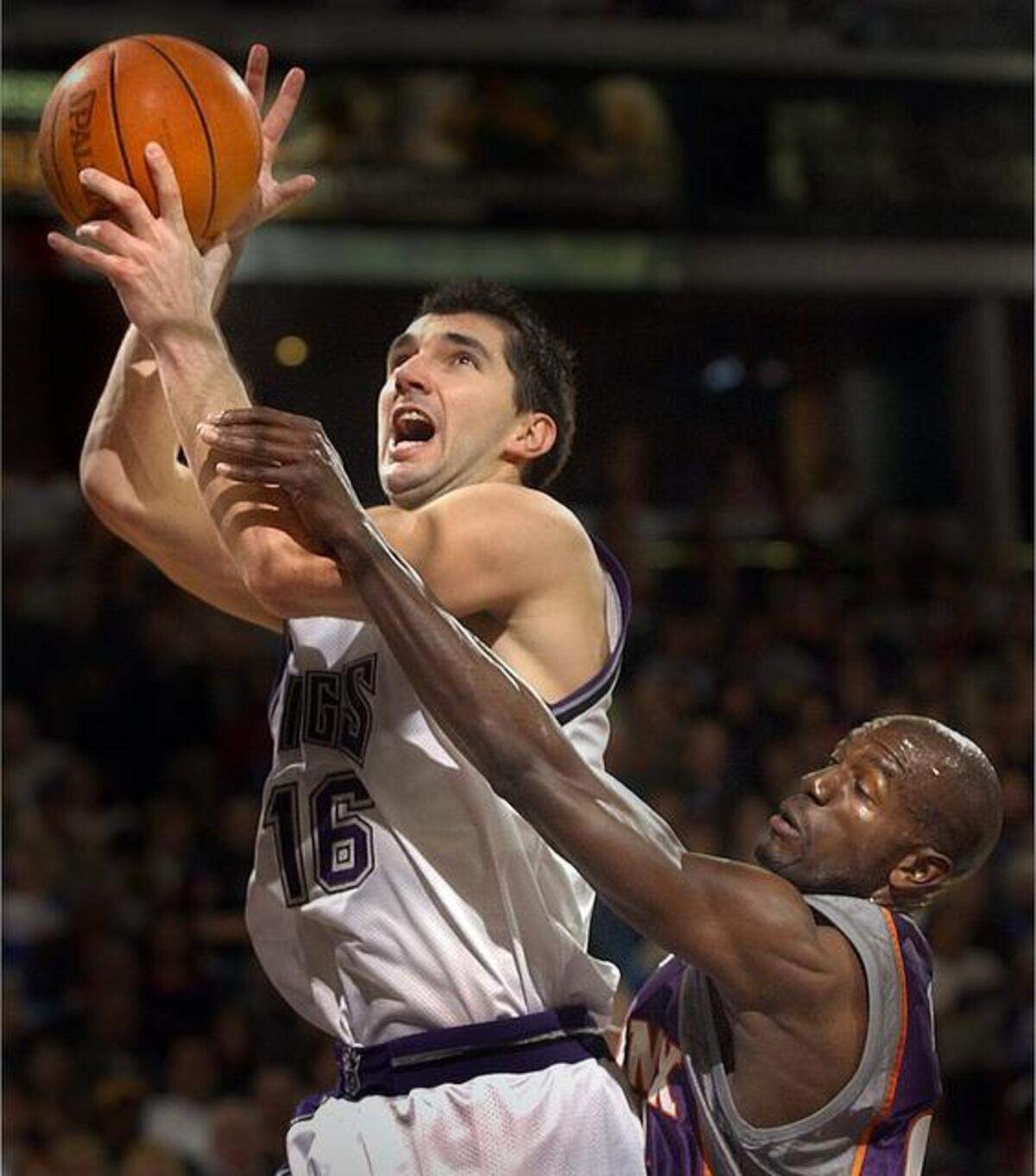 Kings forward Peja Stojakovic is fouled by the Phoenix Suns’ Tony Delk as he drives to the basket en route to a 3-point play on Jan. 13, 2002, at Arco Arena.