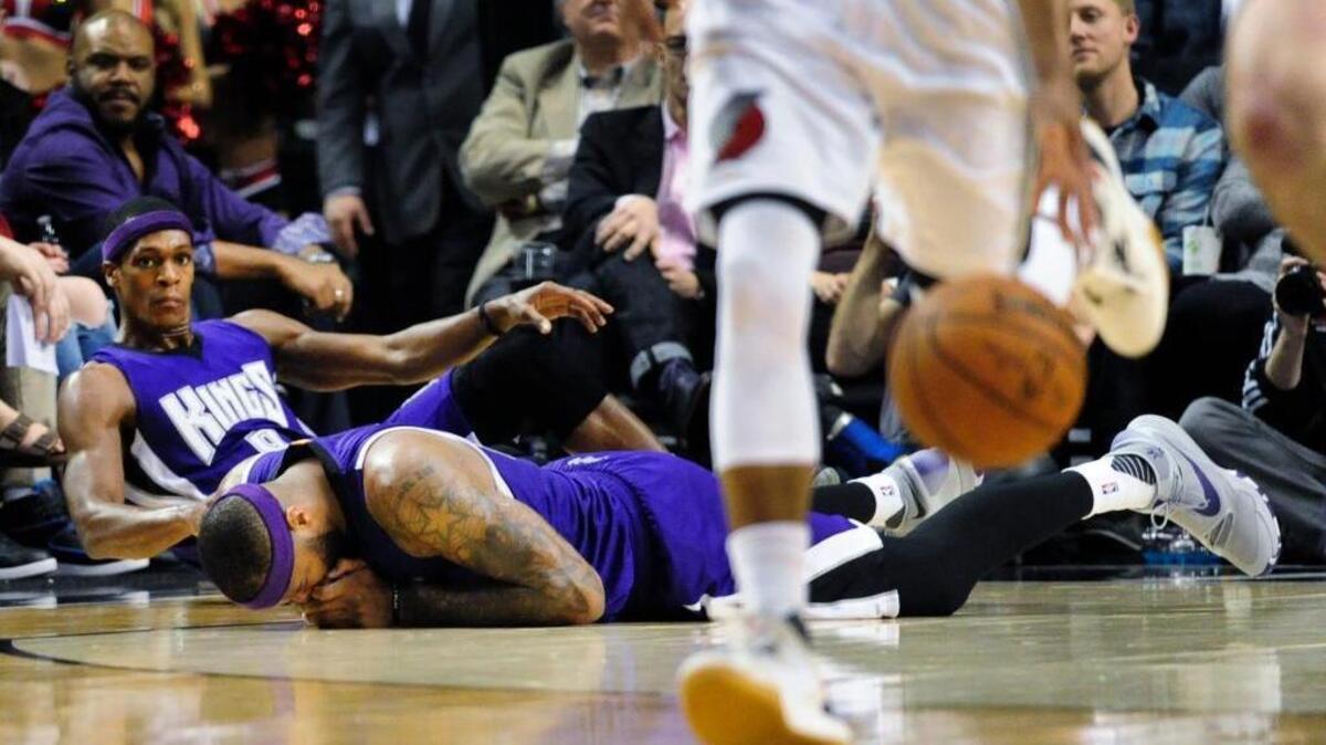 Sacramento Kings guard Rajon Rondo (9) and center DeMarcus Cousins (15) sprawl on the court after a collision during an NBA basketball game against the Portland Trail Blazers in Portland, Ore., Tuesday, Jan. 26, 2016.