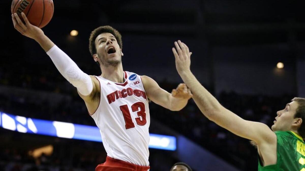Wisconsin forward Duje Dukan (13) drives to the basket over Oregon guard Casey Benson, right, during an NCAA Tournament game on March 22 in Omaha, Neb.