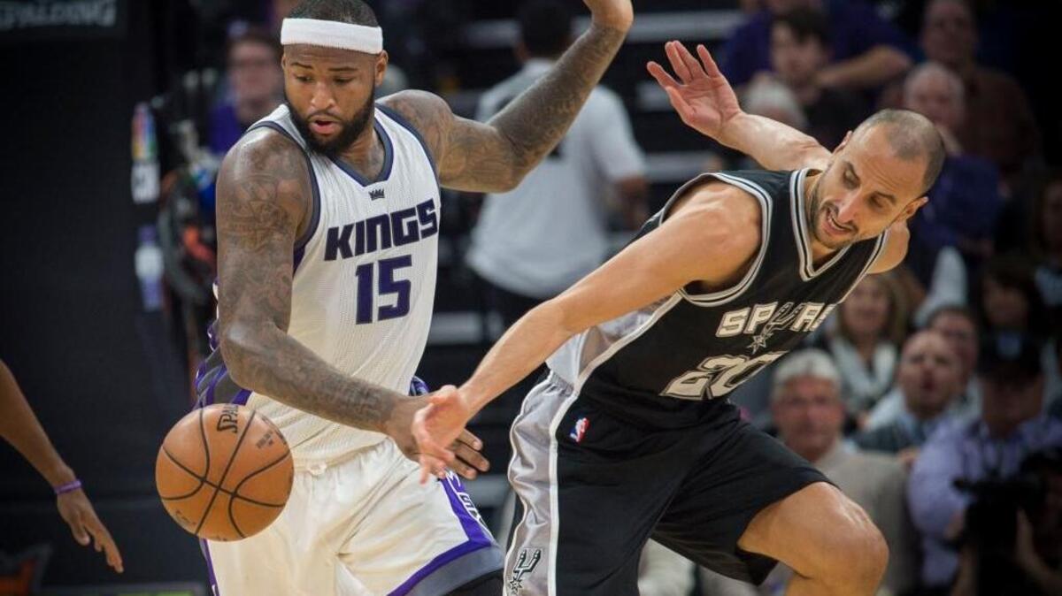 DeMarcus Cousins of the Kings fights for the ball against the Spurs guard Manu Ginobili in Wednesday’s 110-105 loss to San Antonio.