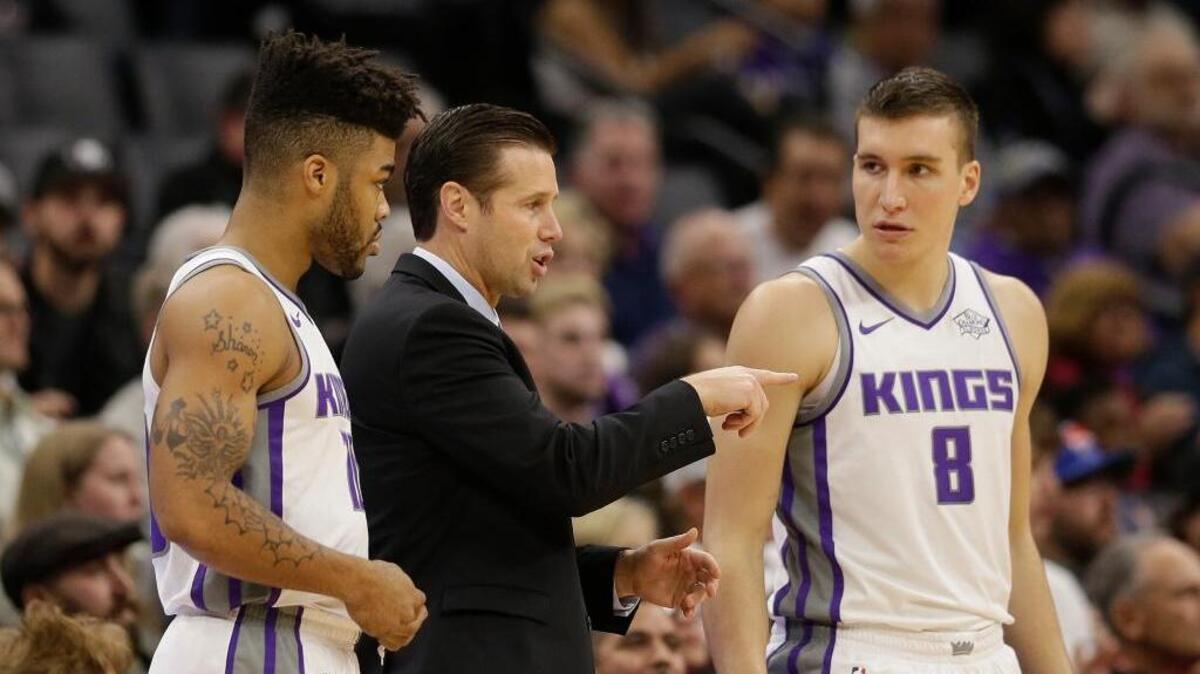 Kings rookies Bogdan Bogdanovic, right, and Frank Mason III speak with coach Dave Joerger during a game early this season.