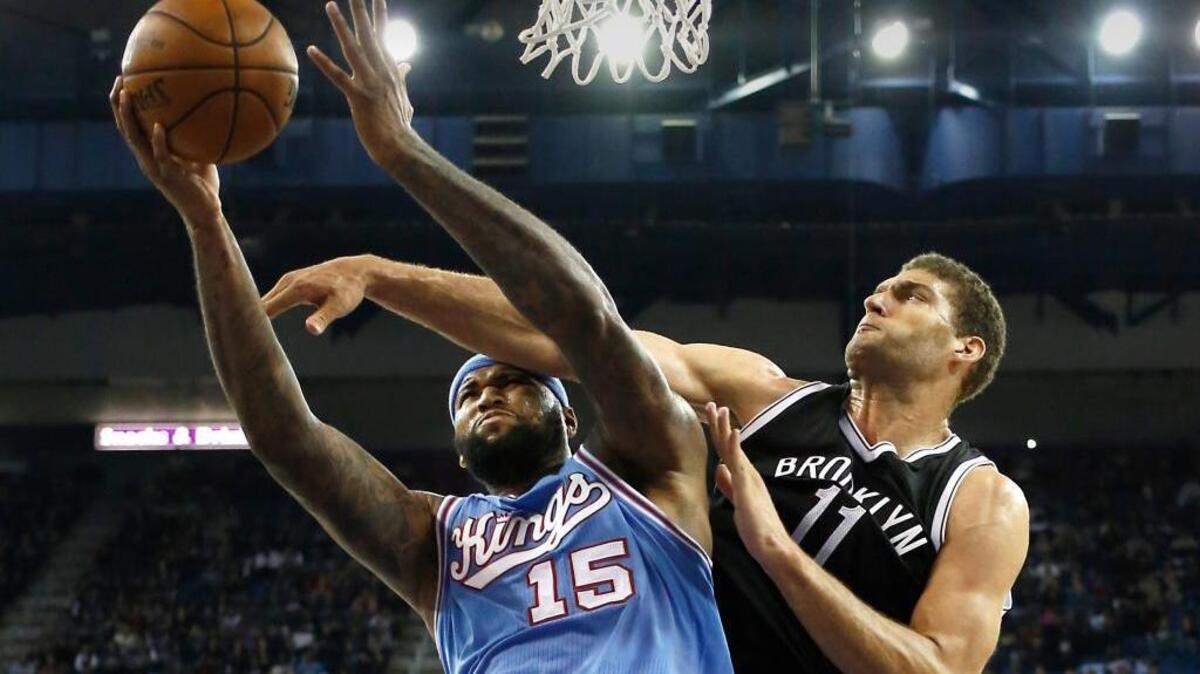 Kings forward DeMarcus Cousins, left, goes to the basket against Brooklyn Nets center Brook Lopez on Friday, Nov. 13, 2015, in Sacramento, Calif. The Kings won 111-109.