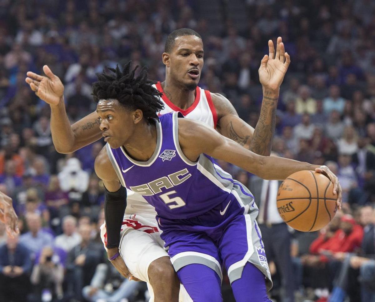Sacramento Kings guard De’Aaron Fox is fouled by Houston Rockets forward Trevor Ariza (1) as he drives to the basket on Wednesday at Golden 1 Center in Sacramento.