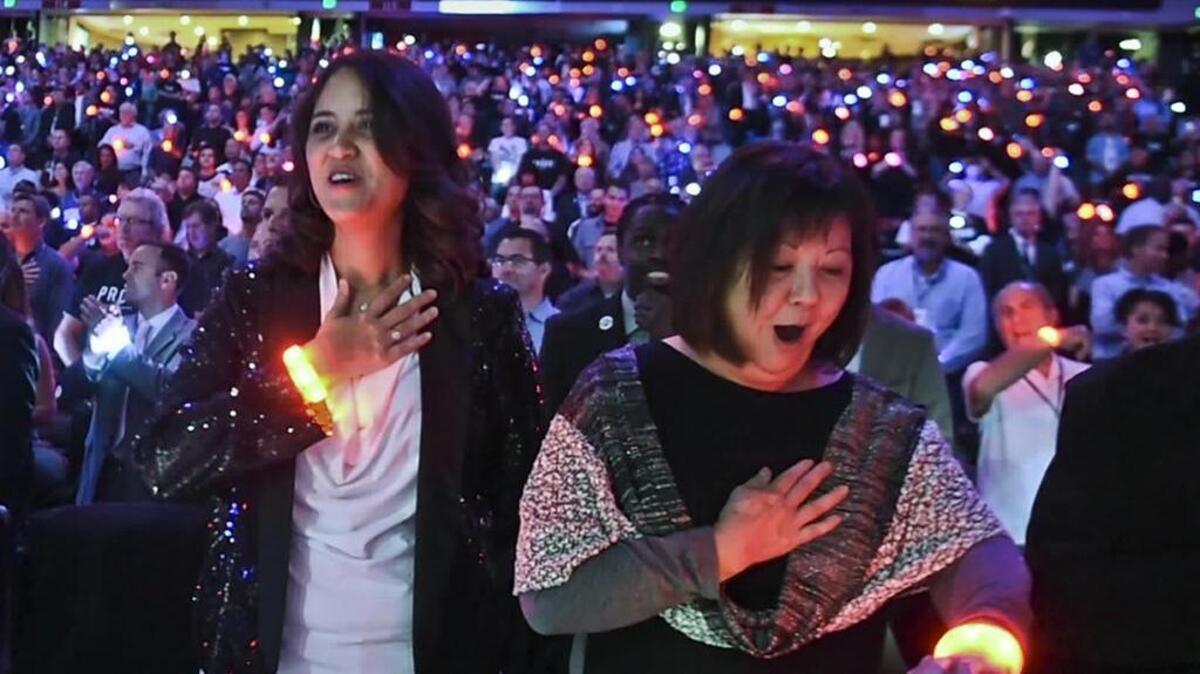 Sacramento Kings season-ticket holder Janice Nall reacts as her LED bracelet lights up during the national anthem Wednesday as she and daughter Sami attend the team’s home opener against the Los Angeles Clippers at Sleep Train Arena.