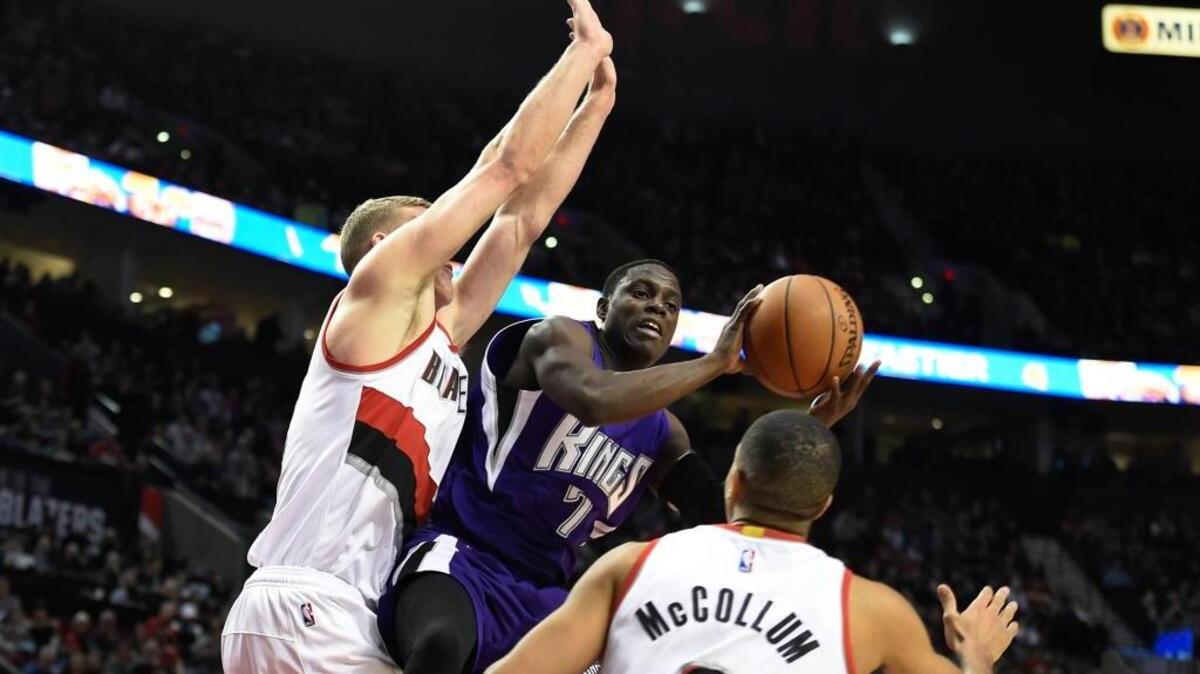 Sacramento Kings guard Darren Collison (7) looks to pass as Portland Trail Blazers center Mason Plumlee goes up for the block and guard C.J. McCollum (3) closes in during an NBA basketball game Monday, March 28, 2016 in Portland, Ore. Collison scored 10 points and had a team-high seven assists.