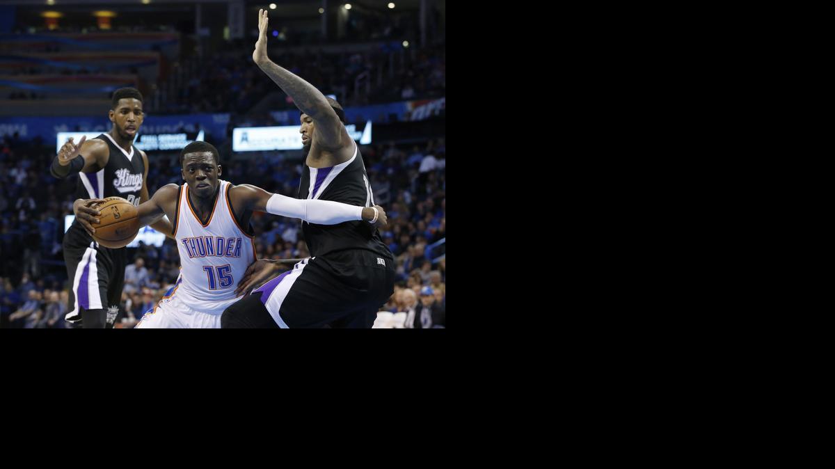
The Thunder’s Reggie Jackson drives between the Kings’ Jason Thompson, left, and DeMarcus Cousins during the third quarter.
