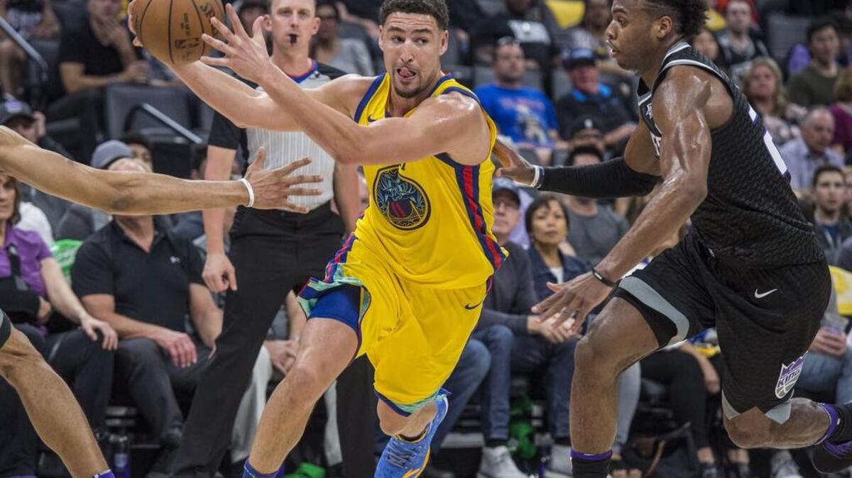 Warriors guard Klay Thompson (11) makes a pass as he drives to the basket against Kings guard Buddy Hield (24).