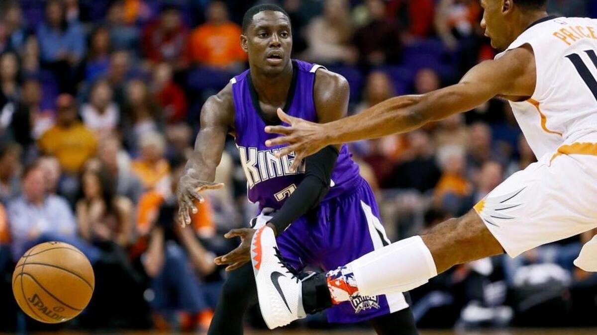 Kings point guard Darren Collison passes under Phoenix Suns’ Ronnie Price on Wednesday, Nov. 4, in Phoenix.