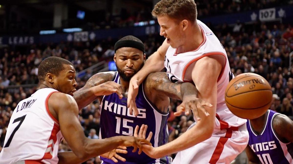 Sacramento Kings center DeMarcus Cousins, center, battles for a loose ball with Toronto Raptors guard Kyle Lowry (7) and center Jakob Poeltl during second-half NBA basketball action in Toronto on Sunday, Nov. 6, 2016.