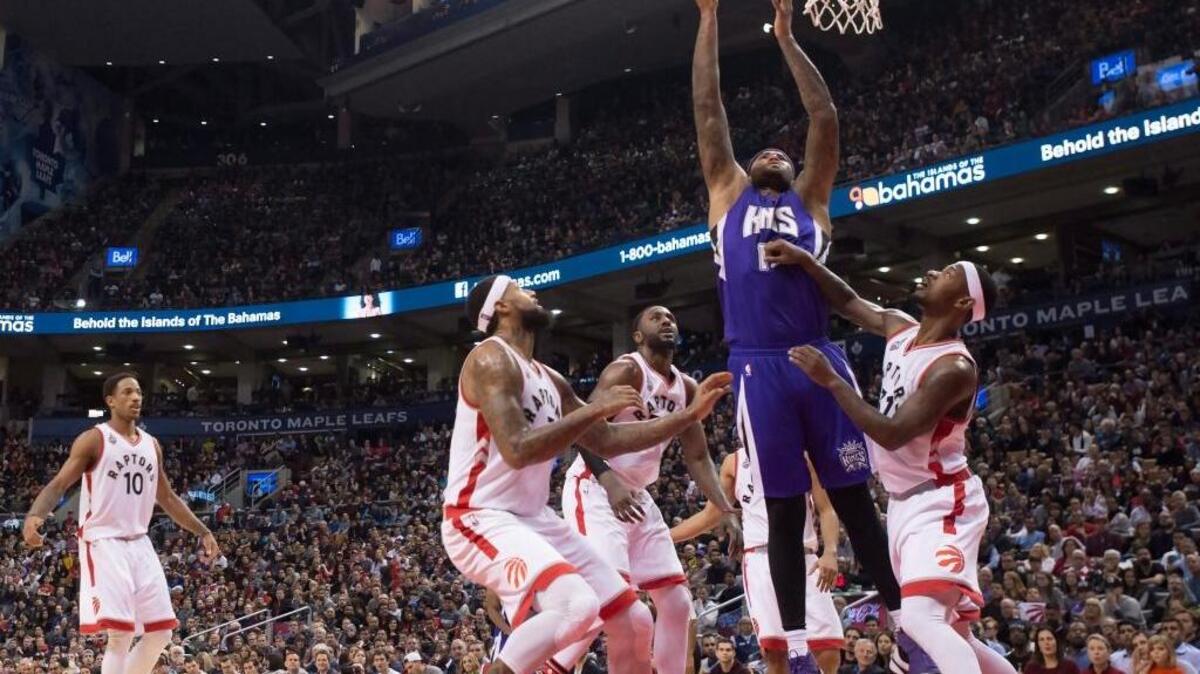 Kings center DeMarcus Cousins, in purple, drives to the hoop against the Toronto Raptors during the fourth quarter Sunday, Dec. 20, 2015, in Toronto.