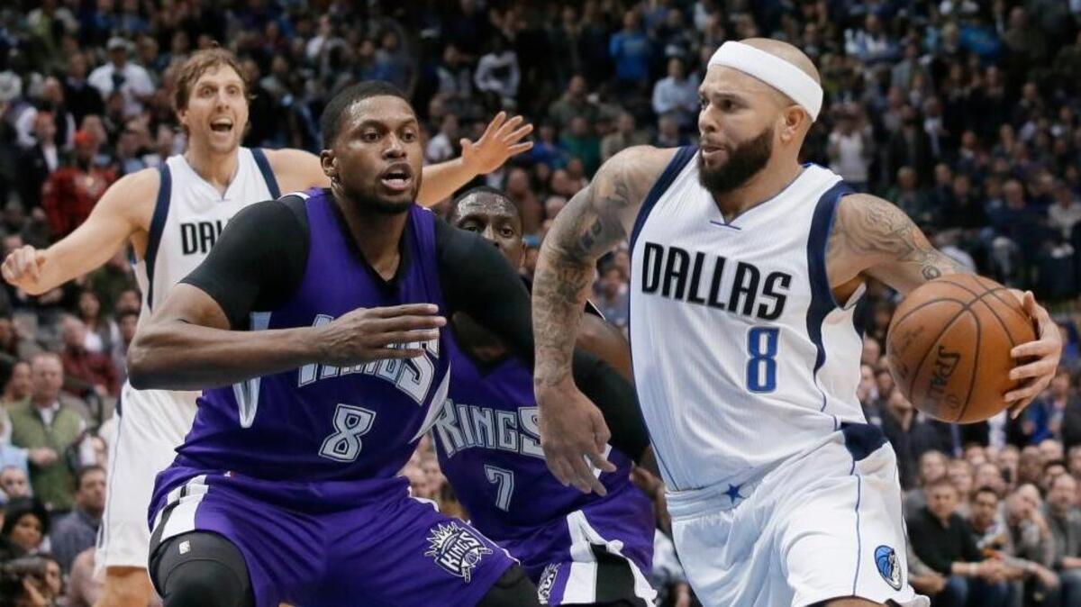Mavericks guard Deron Williams (8) drives against Kings defenders Rudy Gay (8) and Darren Collison (7) as the Mavericks’ Dirk Nowitzki watches during the second overtime in Tuesday night’s game in Dallas. The Mavericks won 117-116.