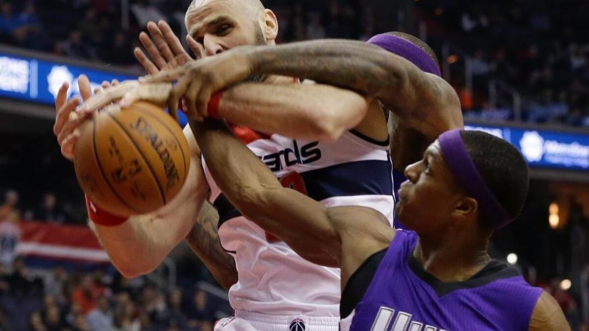 Washington Wizards center Marcin Gortat (13) fights for control of the ball with Sacramento Kings forward DeMarcus Cousins (behind), and guard Rajon Rondo (9) during an NBA basketball game, Monday, Dec. 21, 2015, in Washington. The Wizards won 113-99, and rumblings about Kings coach George Karl’s imminent firing grew louder.