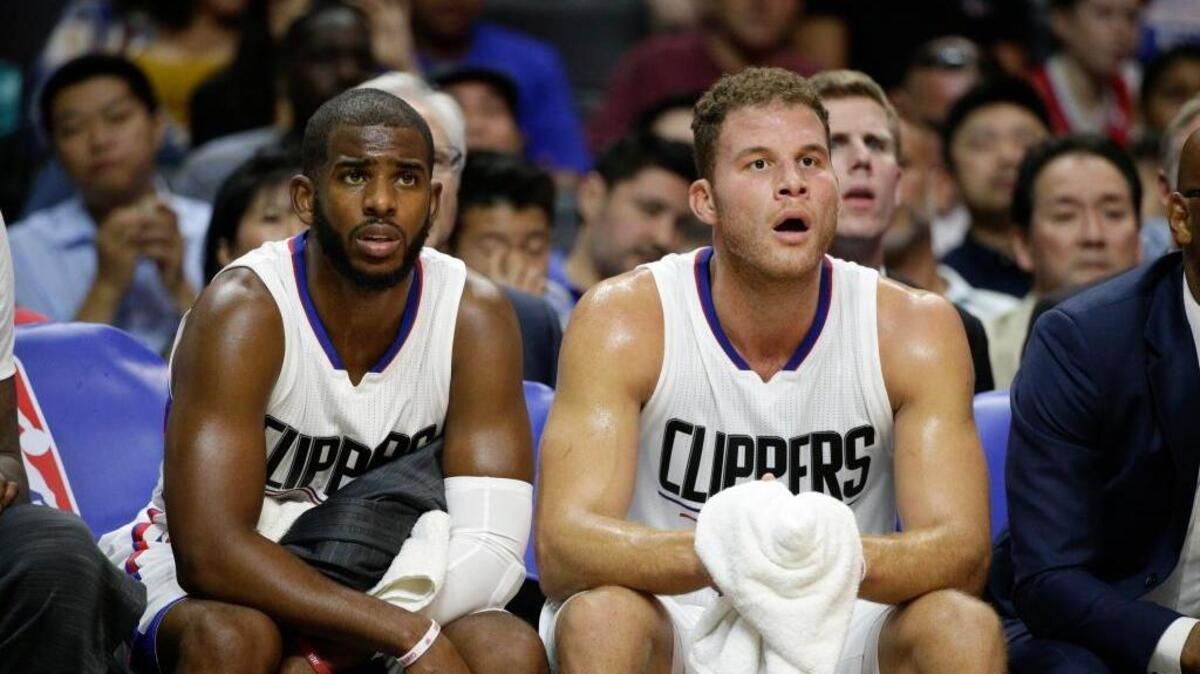 Los Angeles Clippers' Chris Paul, left, and Blake Griffin watch from the bench during the first half of an NBA preseason basketball game against the Golden State Warriors, Tuesday, Oct. 20, 2015, in Los Angeles.