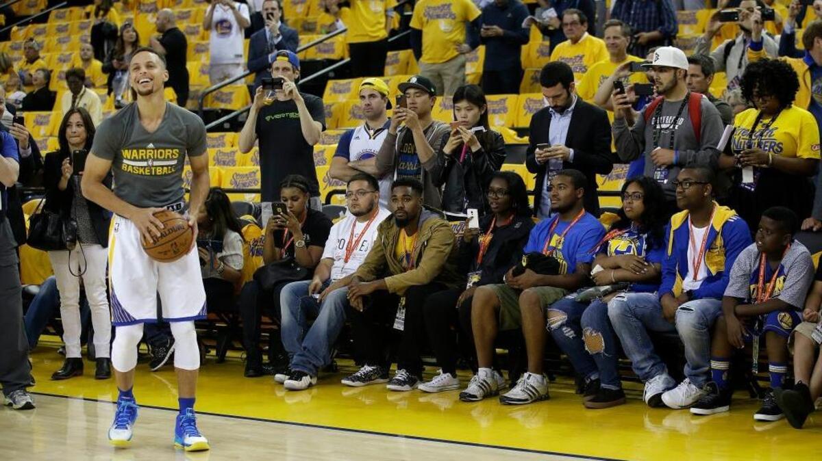 Fans watch as Golden State Warriors guard Stephen Curry warms up before Game 5 of basketball’s NBA Finals between the Warriors and the Cleveland Cavaliers, Monday, June 13, 2016. The mood was decidely lighter before the game than after the Cavs staved off elimination with a 112-97 victory.