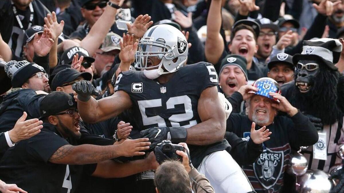 Oakland Raiders defensive end Khalil Mack (52) celebrates with fans after scoring a touchdown during an NFL football game against the Carolina Panthers in Oakland, Calif., on Sunday, Nov. 27, 2016. Mack was named The Associated Press Defensive Player of the Year on Saturday, Feb. 4, 2017.