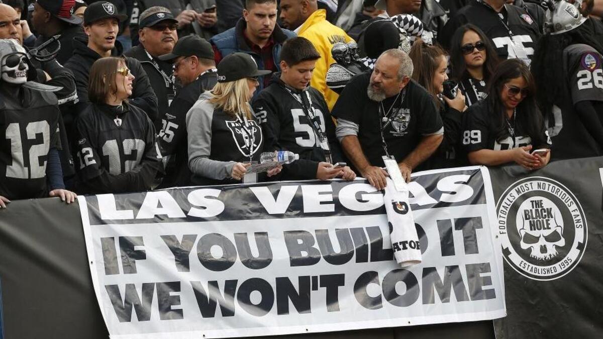 Oakland Raiders fans hold up a sign about the team's possible move to Las Vegas during the second half of an NFL football game between the Oakland Raiders and the Carolina Panthers in Oakland, Calif., Sunday, Nov. 27, 2016.