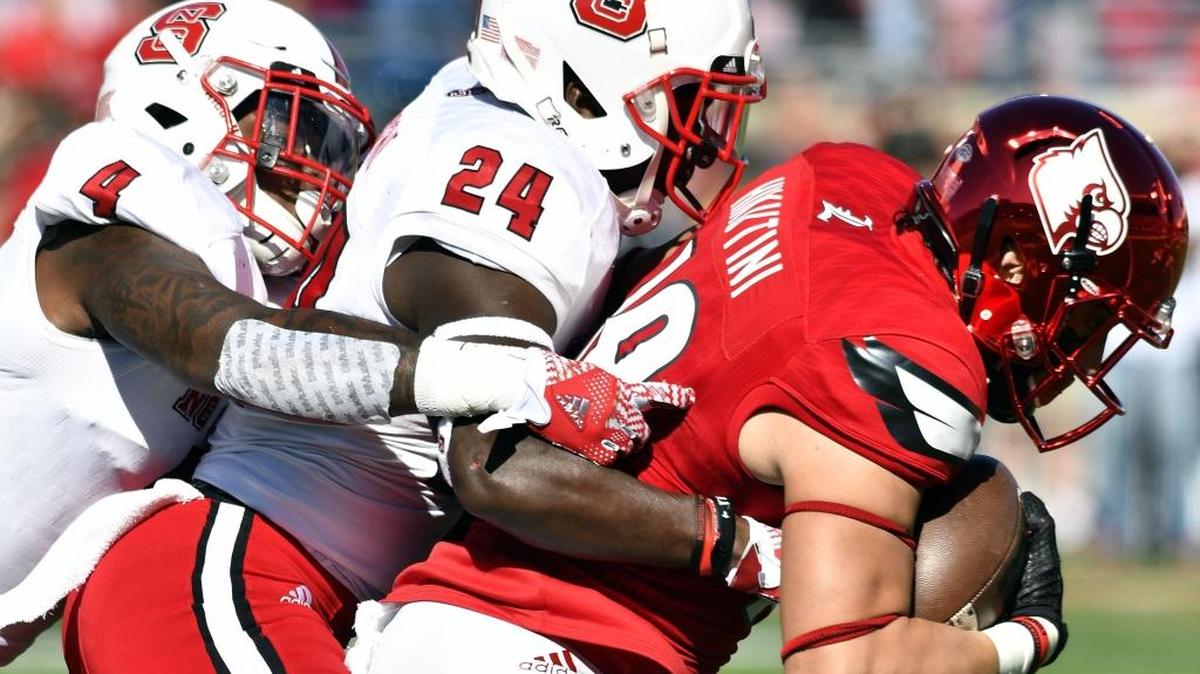 Louisville’s Cole Hikutini (18) is brought down by North Carolina State's Shawn Boone (24) and Jerod Fernandez (4) during the first half of their NCAA college football game, Saturday, Oct. 22, 2016, in Louisville, Ky. Hikutini was signed as an undrafted free agent by the 49ers on Saturday.