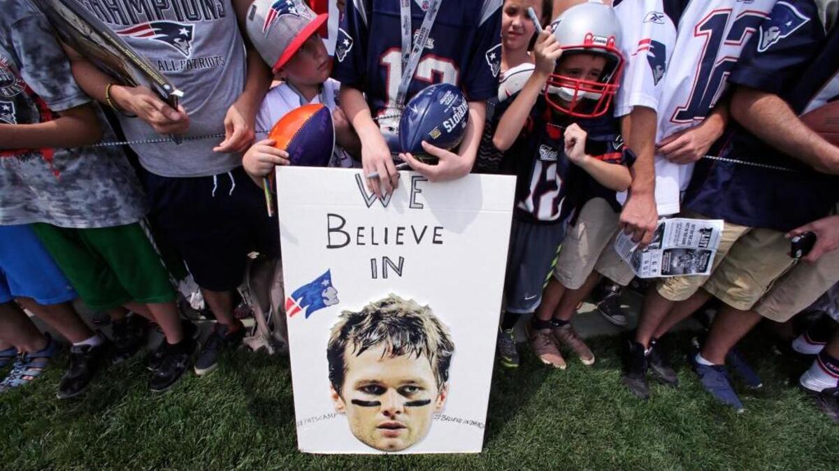 
In this July 30, 2015, photo, New England Patriots fans wait for practice to complete, while standing behind a sign supporting quarterback Tom Brady during an NFL football training camp in Foxborough, Mass. A federal judge on Thursday erased Brady’s four-game suspension.
