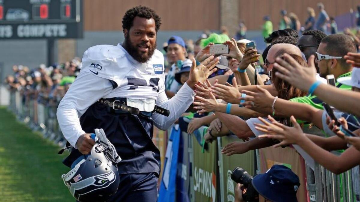 Seattle Seahawks defensive lineman Michael Bennett greets fans during training camp Aug. 4 in Renton, Wash. Bennett did not stand during the national anthem Sunday before a game against the Los Angeles Chargers in Carson.