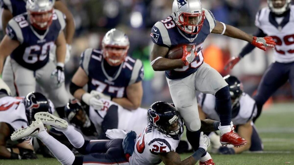 New England Patriots running back Dion Lewis (33) tries to elude Houston Texans cornerback Kareem Jackson (25) during an NFL divisional playoff football game, Saturday, Jan. 14, 2017, in Foxborough, Mass. Lewis scored three touchdowns (kickoff return, pass reception, run).