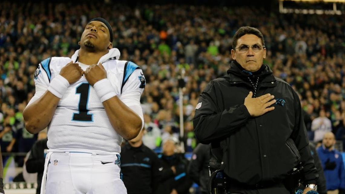 Carolina Panthers head coach Ron Rivera, right, and quarterback Cam Newton stand on the sidelines during the national anthem before an NFL football game against the Seattle Seahawks, Sunday, Dec. 4, 2016, in Seattle. The Seahawks won the game 40-7.