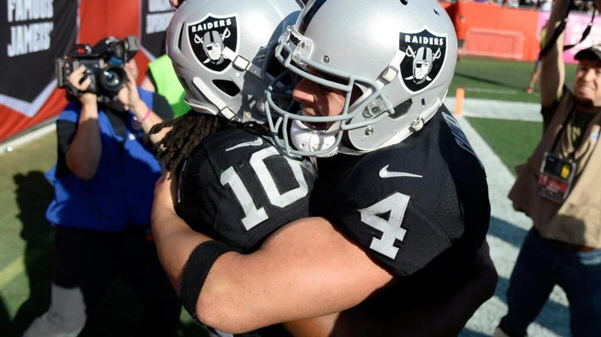 Raiders quarterback Derek Carr (4) hugs wide receiver Seth Roberts after Roberts scored on a 41-yard touchdown reception from Carr on fourth down late in overtime Sunday in Tampa, Fla. The Raiders won the game 30-24.