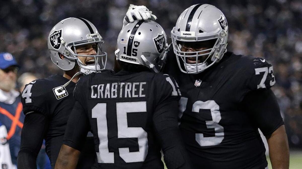 Raiders wide receiver Michael Crabtree (15) celebrates with quarterback Derek Carr, left, and offensive tackle Marshall Newhouse (73) after scoring a touchdown against the Dallas Cowboys on Dec. 17 in Oakland.