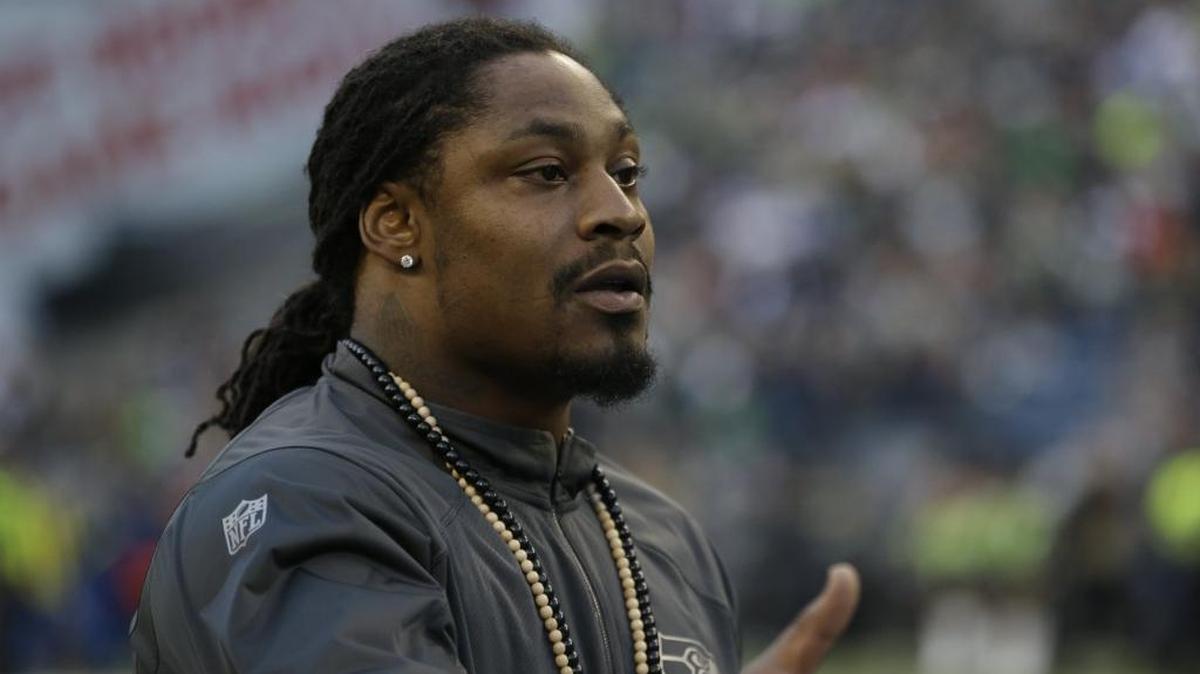 FILE - Running back Marshawn Lynch, then with the Seahawks, shakes hands during the coin toss before a preseason NFL football game against the Oakland Raiders, Thursday, Sept. 3, 2015, in Seattle. Lynch came out of retirement in April to sign with the Raiders.